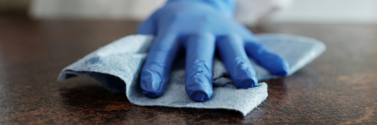 Hand with a cloth cleaning the vinyl of a treatment chair