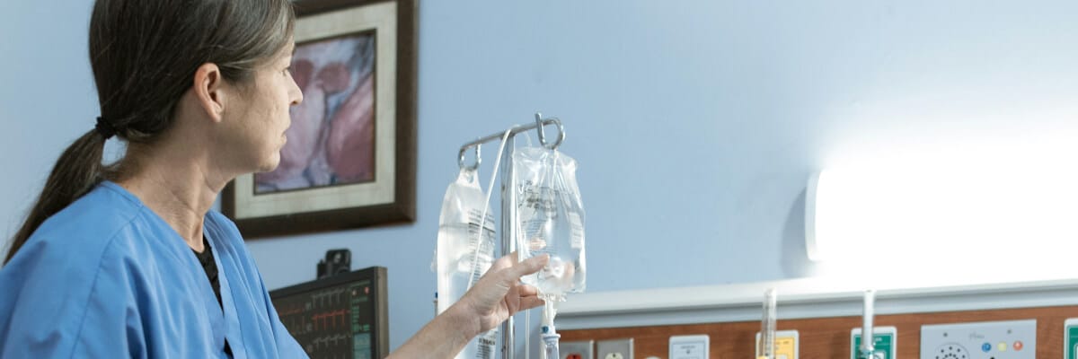 Nurse hanging an IV bag on a stand